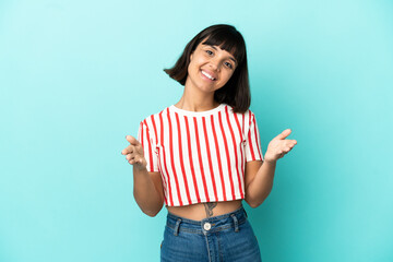Young mixed race woman isolated on blue background presenting and inviting to come with hand