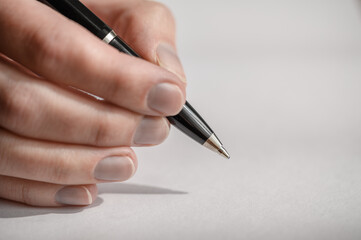 Zbliżenie na długopis w dłoni podczas pisania listu ręcznie 