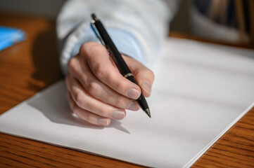 Pisać testament, zbliżenie na dłoń nad kartką papieru