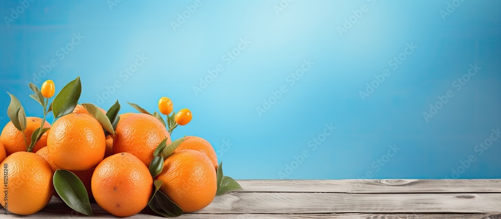 Aufkleber The vibrant orange fruits are displayed on a rustic wooden table creating a captivating contrast against the serene blue backdrop in the copy space image