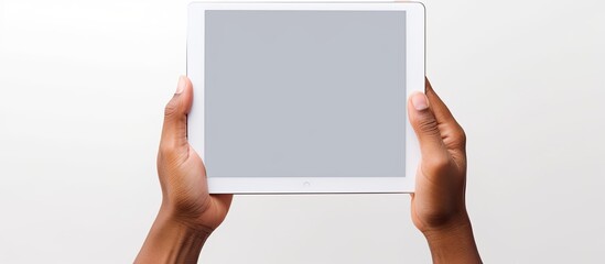 A white background with a hand holding a tablet PC featuring a blank screen to insert an image. Creative banner. Copyspace image