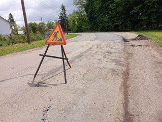 The road works sign stands in the middle of the road and blocks the carriageway. road signs are...