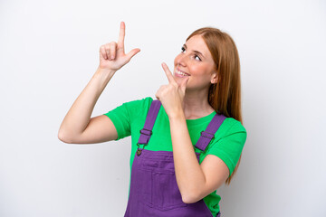 Young redhead woman isolated on white background pointing with the index finger a great idea