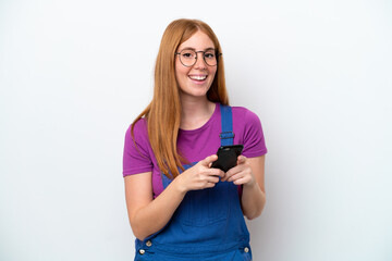 Young redhead woman isolated on white background surprised and sending a message