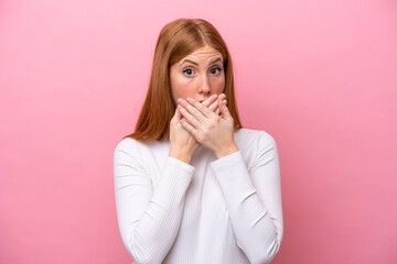Young redhead woman isolated on pink background covering mouth with hands