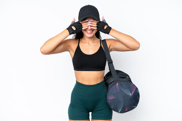 Young sport woman with sport bag isolated on white background covering eyes by hands