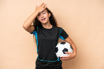 Young football player woman isolated on beige background has realized something and intending the...