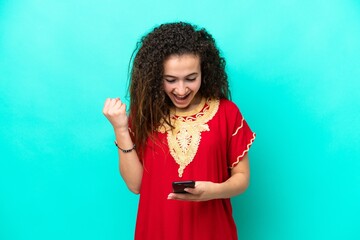 Young Arab woman isolated on blue background surprised and sending a message