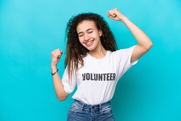 Young Arab volunteer woman isolated on blue background celebrating a victory