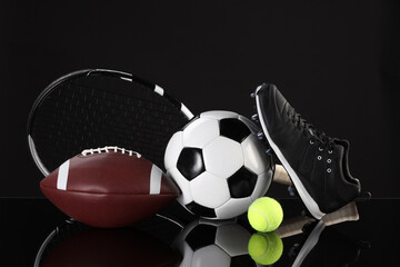 Many different sports equipment on black mirror surface