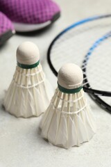 Feather badminton shuttlecocks and rackets on gray background, closeup