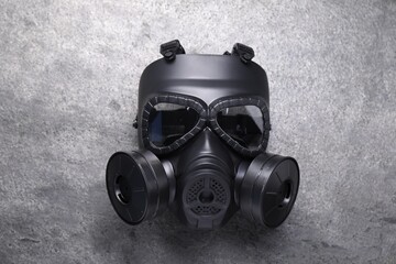 One gas mask on grey textured background, top view