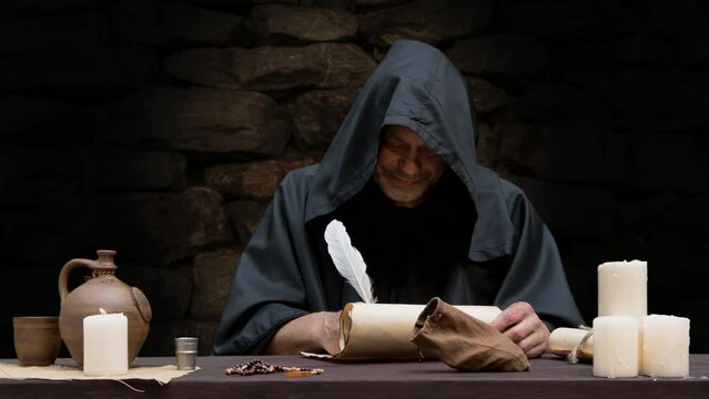 A monk in a cell writing a message on parchment with a quill pen, dipping the quill in an inkwell, dark tonality.