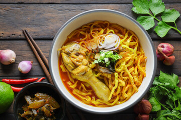 Thai food,Khao Soi Recipe,Khao Soi,Khao Soi Kai, Thai Noodles Khao Soi, Chicken Curry with seasoning on wooden floor, Northern Thai food concept. (Lanna food)
