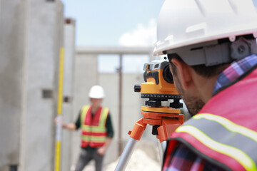 A civil engineer or construction engineer is using a survey camera. An engineer who specializes in construction is using an Auto Level camera.