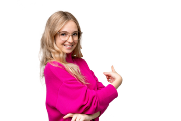 Young English woman over isolated background pointing back