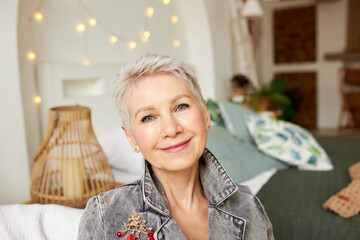 Pretty happy photogenic senior caucasian female designer in denim jacket looking at camera posing...