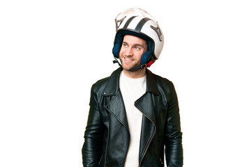 Young handsome blonde man with a motorcycle helmet over isolated chroma key background looking to the side and smiling