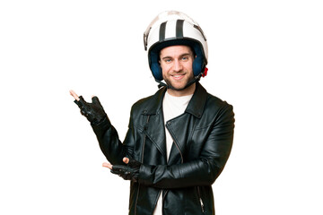 Young handsome blonde man with a motorcycle helmet over isolated chroma key background extending hands to the side for inviting to come