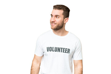 Fototapeta premium Young volunteer man over isolated chroma key background looking to the side and smiling