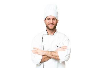 Young blonde man Chef over isolated chroma key background keeping the arms crossed in frontal position