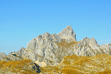 The highest point of the Durmitor National Park, the peak of Bobotov Kuk, against the backdrop of a blue cloudless sky. Landscape from the north of Montenegro.