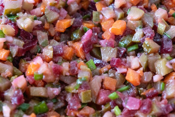 A tasty salad named Vinaigrette - a traditional Ukrainian and Russian  vegetable salad.  Vegetarian dish. Vegan food with green onion, boiled potatoes, carrot, beet. Salad background