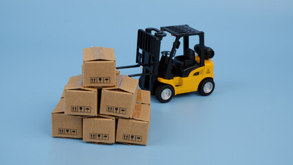 Many carton boxes and yellow forklift truck. Logistics, delivery and cargo concept.
