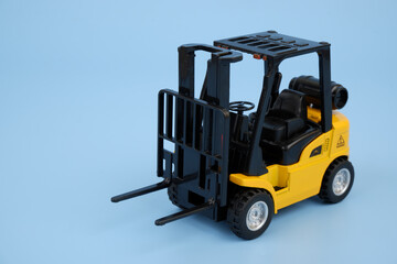 Yellow forklift truck on blue background. Copy space for text.