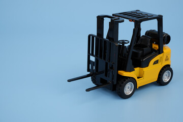 Forklift truck model on blue background. Copy space for text.