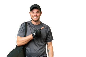 Young sport man with sport bag over isolated chroma key background pointing to the side to present a product
