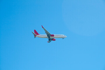 Generic airplane without markings, in red and white on a blue sky background