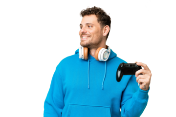 Brazilian man playing with a video game controller over isolated chroma key background looking side