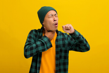 Young Asian man, wearing a beanie hat and casual shirt, appears to be experiencing throat pain and...