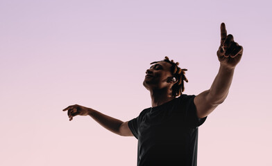 Energetic man dancing to music with eyes closed in studio silhouette