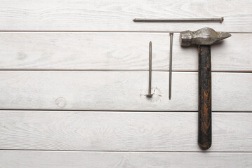 Construction concept background. Work tool hammer and nails on the wooden workbench background. Top view. Flat lay.