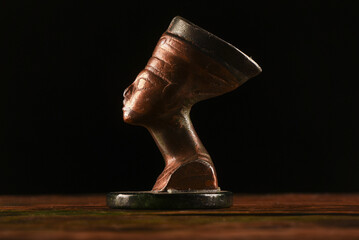 Bust of Nefertiti on the table on the dark background.Ancient Egypt concept background.