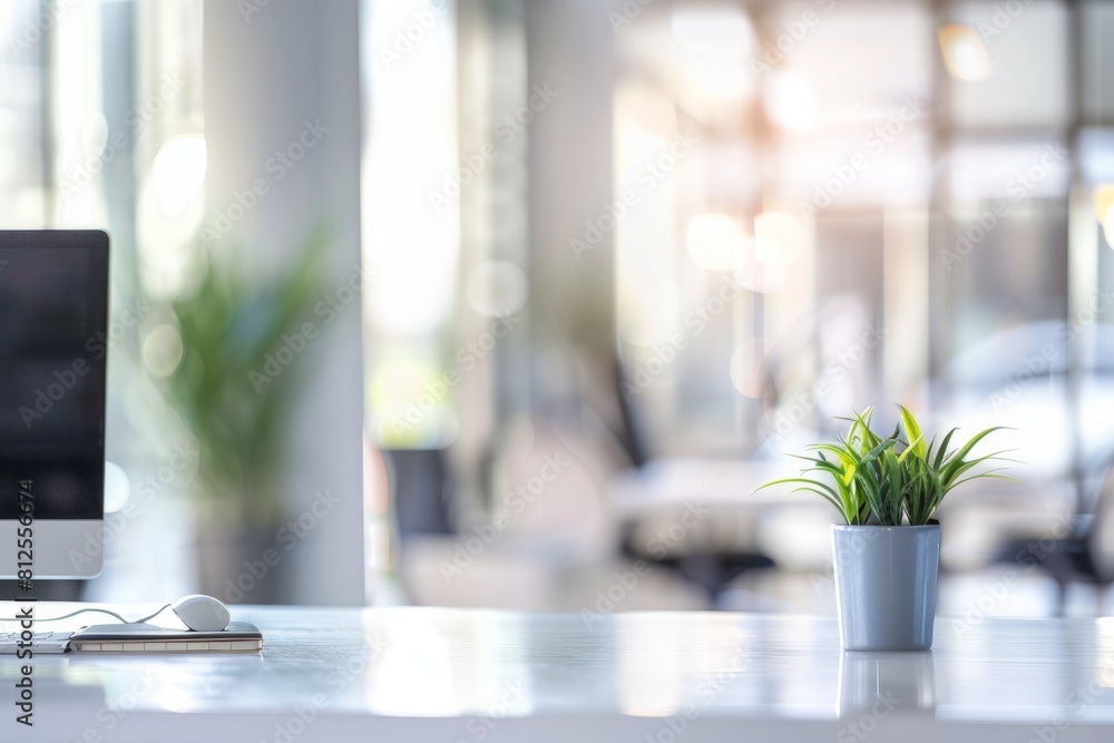 Aufkleber a computer placed on a desk with a plant next to it in a bright office setting