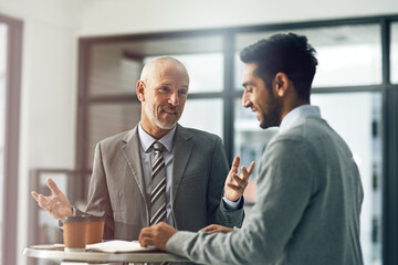 Mature, man and male person for mentor, paperwork and coffee in office for advice in business. Senior, employee and intern as coworkers in meeting for brainstorming, ideas and smile in corporate