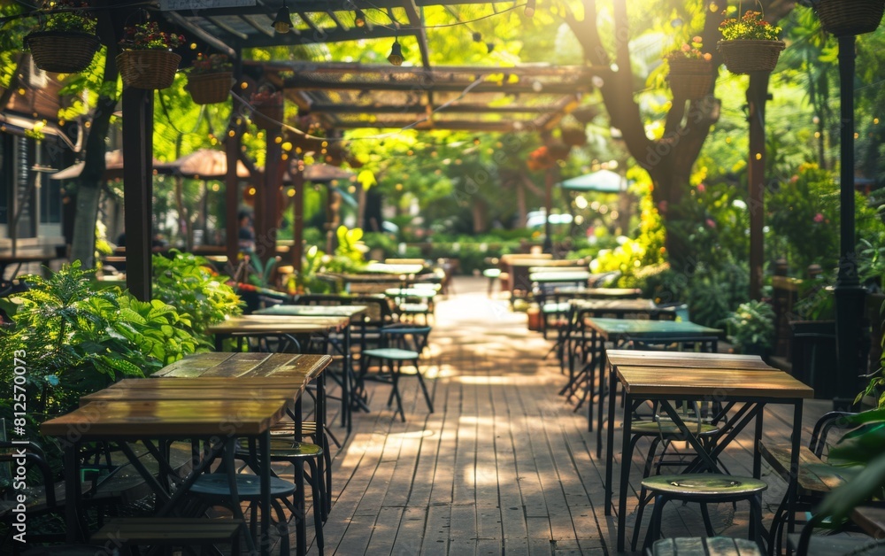 Poster a restaurant patio with tables and chairs, and a large tree in the background. the tables are empty,