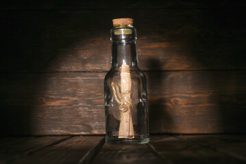 Message scroll letter in the bottle on the wooden desk tablebackground  front view close up....
