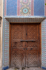 Fez, old wooden door with beautiful carved decoration and antique latch. Medina of the old city Morocco
