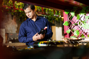 Hispanic man enjoy testing a wine at the wine restaurant.