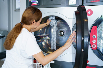 Woman washing clothes at washing KIOSK vendor.