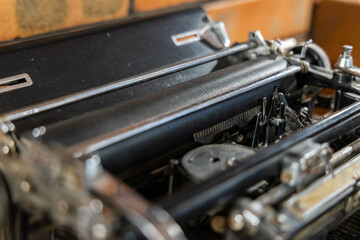 A close up of an old fashioned typewriter with its keys resting on the dusty paper tray, showcasing...