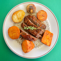 A baked dinner featuring sliced leg of lamb with vegetables and lemon thyme.