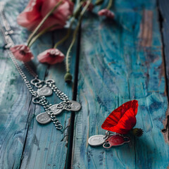 A vintage blue wood table displays a somber red poppy and dog tags in Memorial Day tribute.