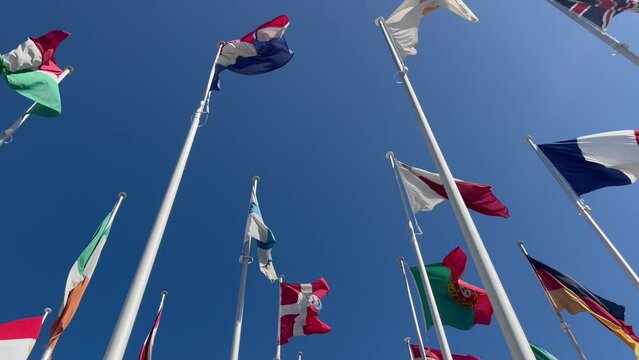 Flags of many countries waveing in the wind with blue sky from below