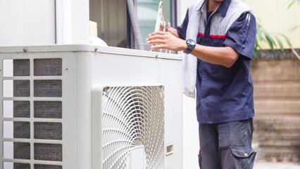 Selective focus of Air conditioner compressor with blurred technician man cleaning air conditioner...
