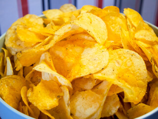 Snack Time. Vibrant potato chips in a blue bowl, ideal for casual dining imagery.